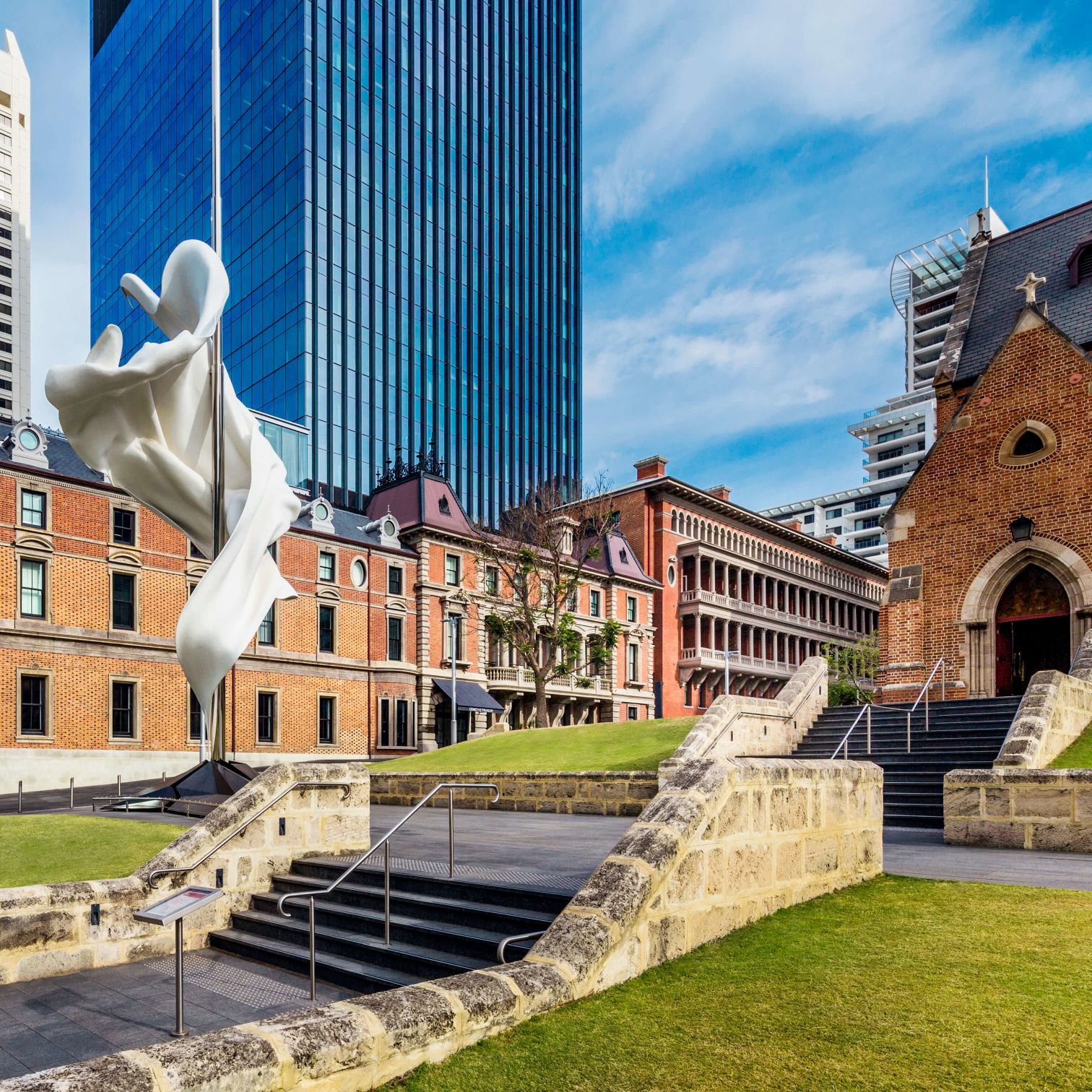A Statue Of A Person Holding A Torch In Front Of A Building