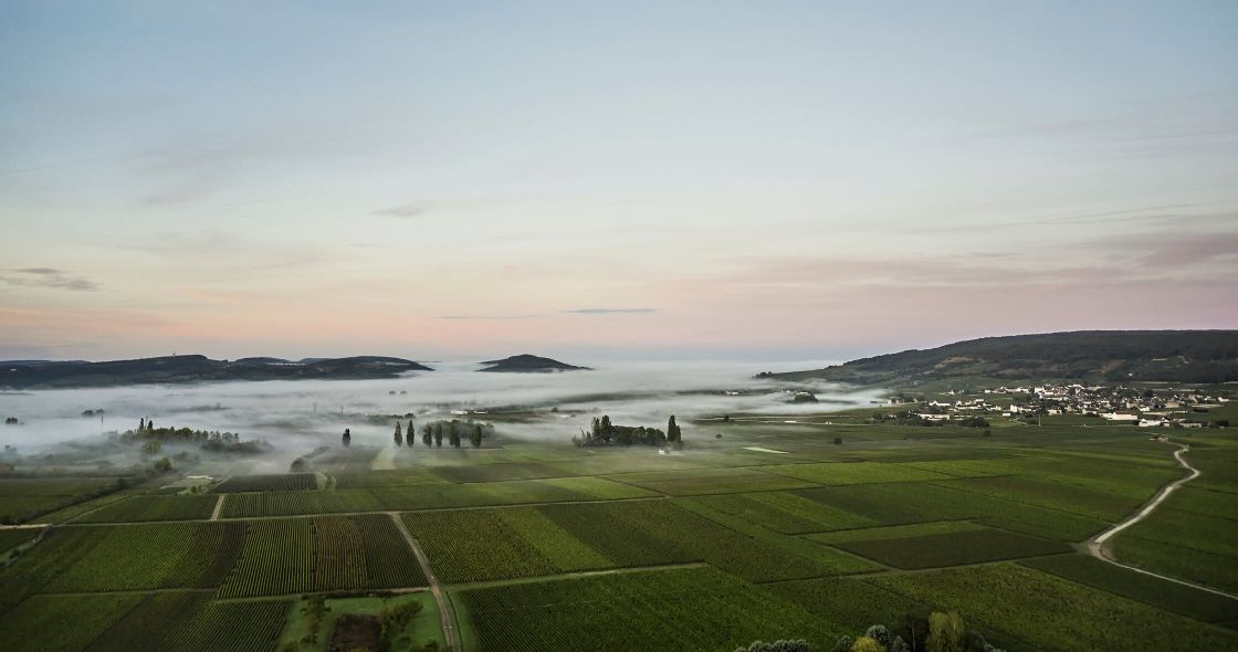 A Landscape With A Body Of Water And Land With Buildings In The Distance With Pebble Beach Golf Links In The Background
