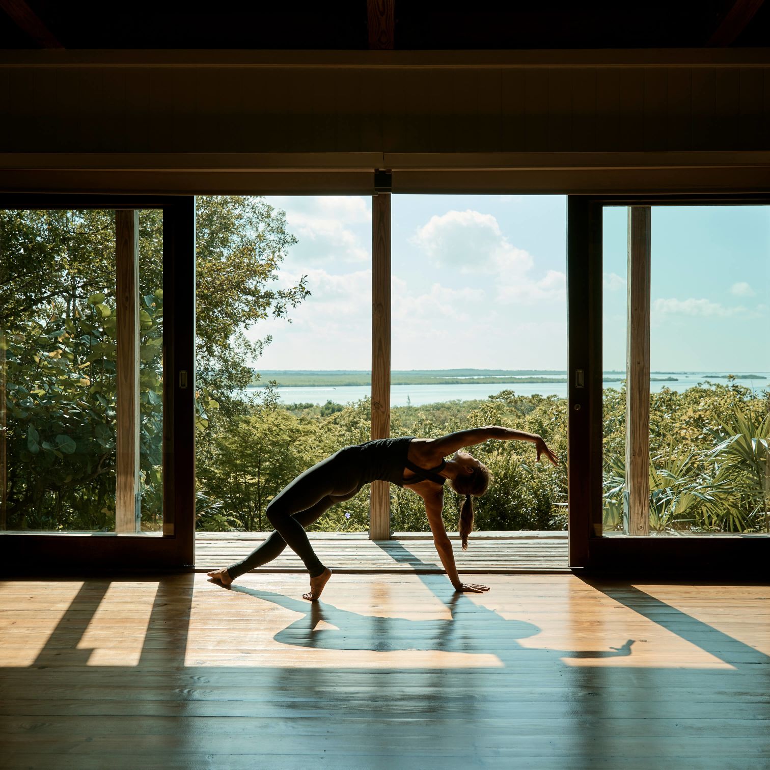 A Person Doing A Yoga Pose In Front Of A Window