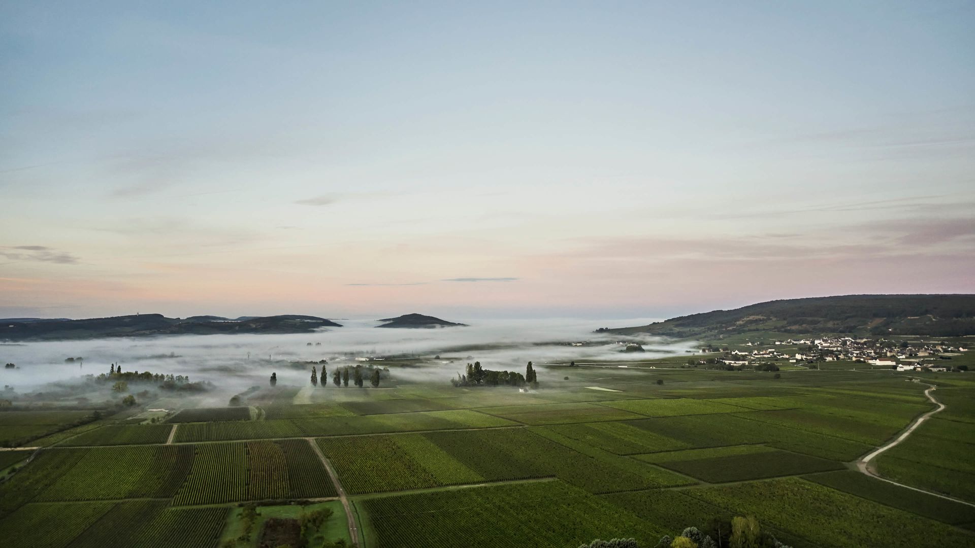 A Landscape With A Body Of Water In The Back With Pebble Beach Golf Links In The Background
