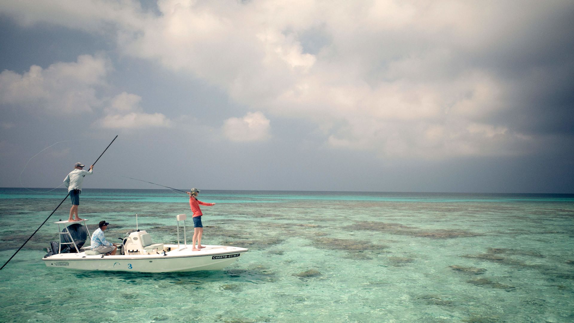 A Group Of People Fishing On A Small Boat In The Ocean