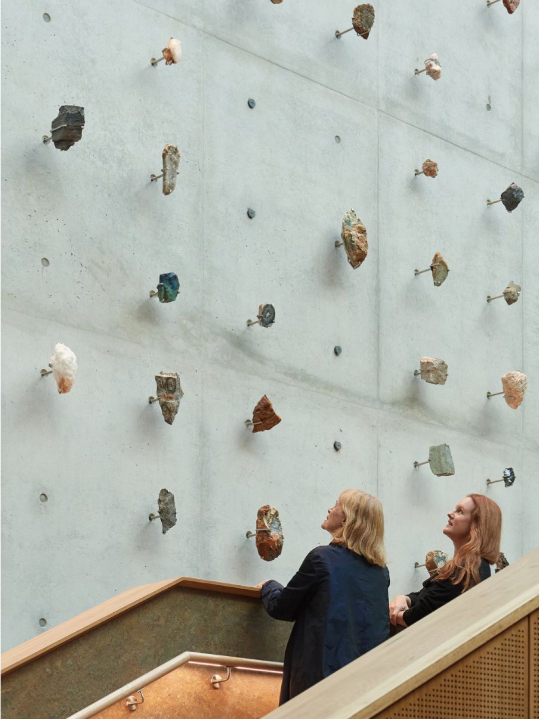 A Group Of People Looking At A Wall With Holes In It