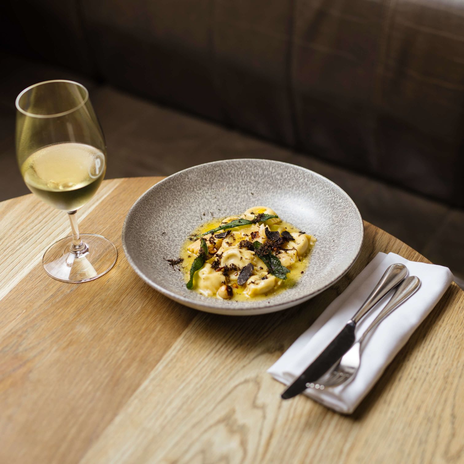 A Bowl Of Food And A Glass Of Wine On A Table