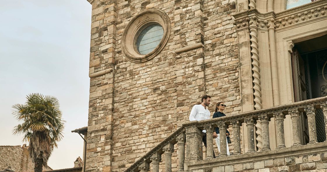 A Man And Woman Standing On A Staircase Outside A Building