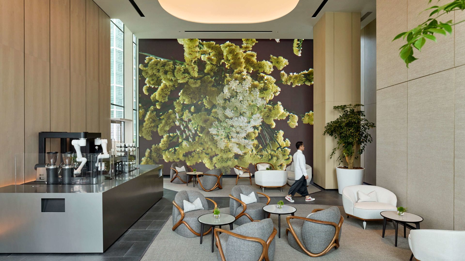 A Person Walking In A Room With A Large Plant