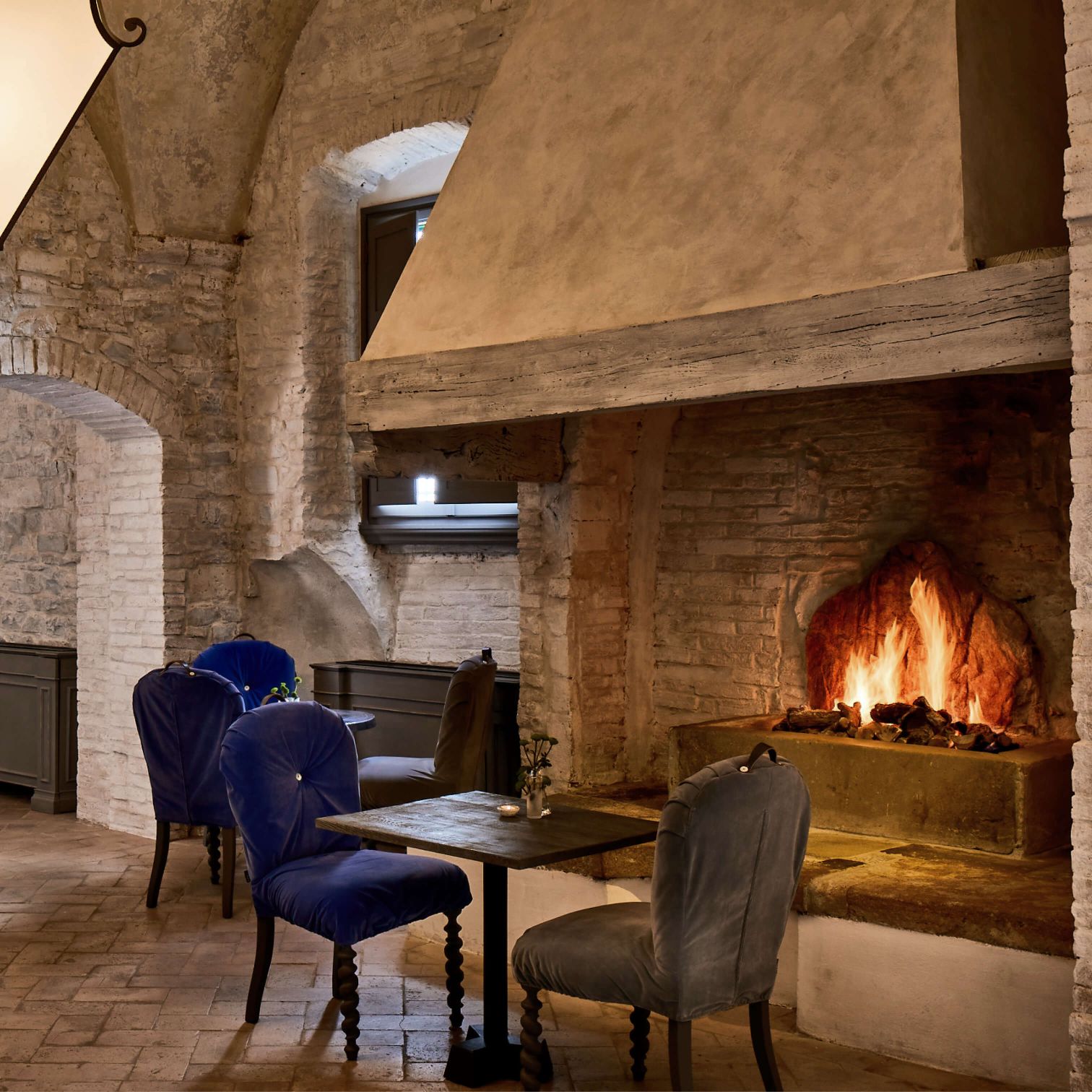 A Table And Chairs In A Room With A Fireplace