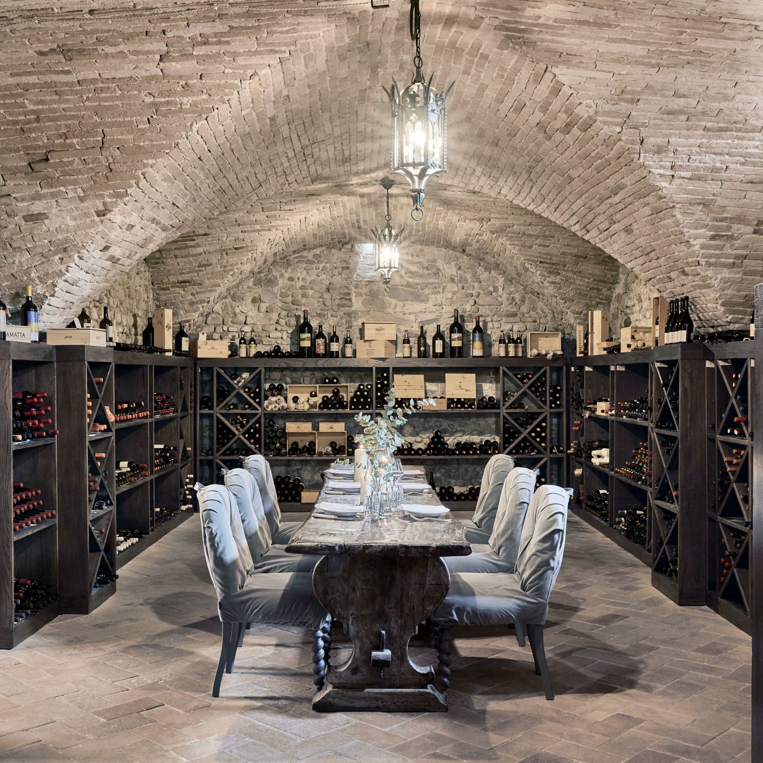 A Table With Chairs And A Chandelier In A Room With Shelves