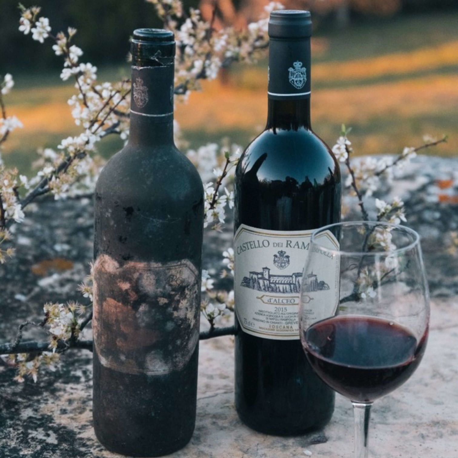A Couple Of Bottles And A Glass Of Wine On A Table
