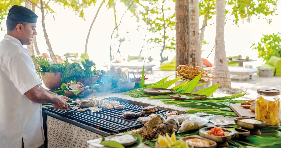 A Person Cooking Food On A Grill