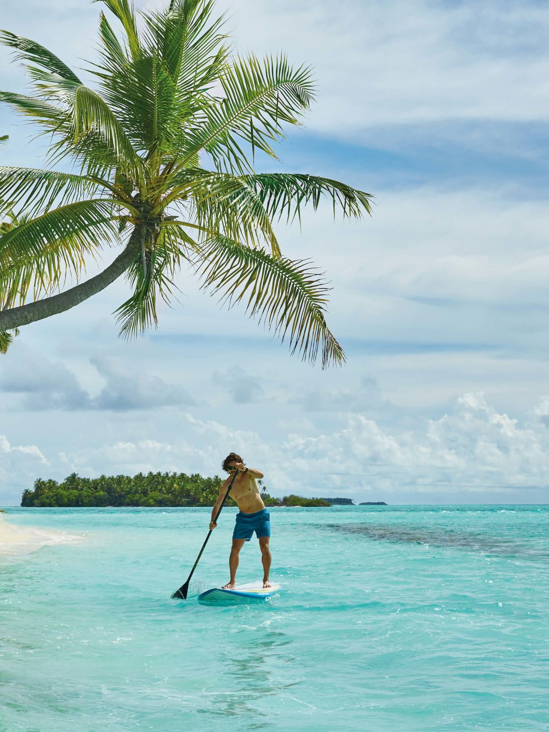A Man Paddle Boarding In The Ocean