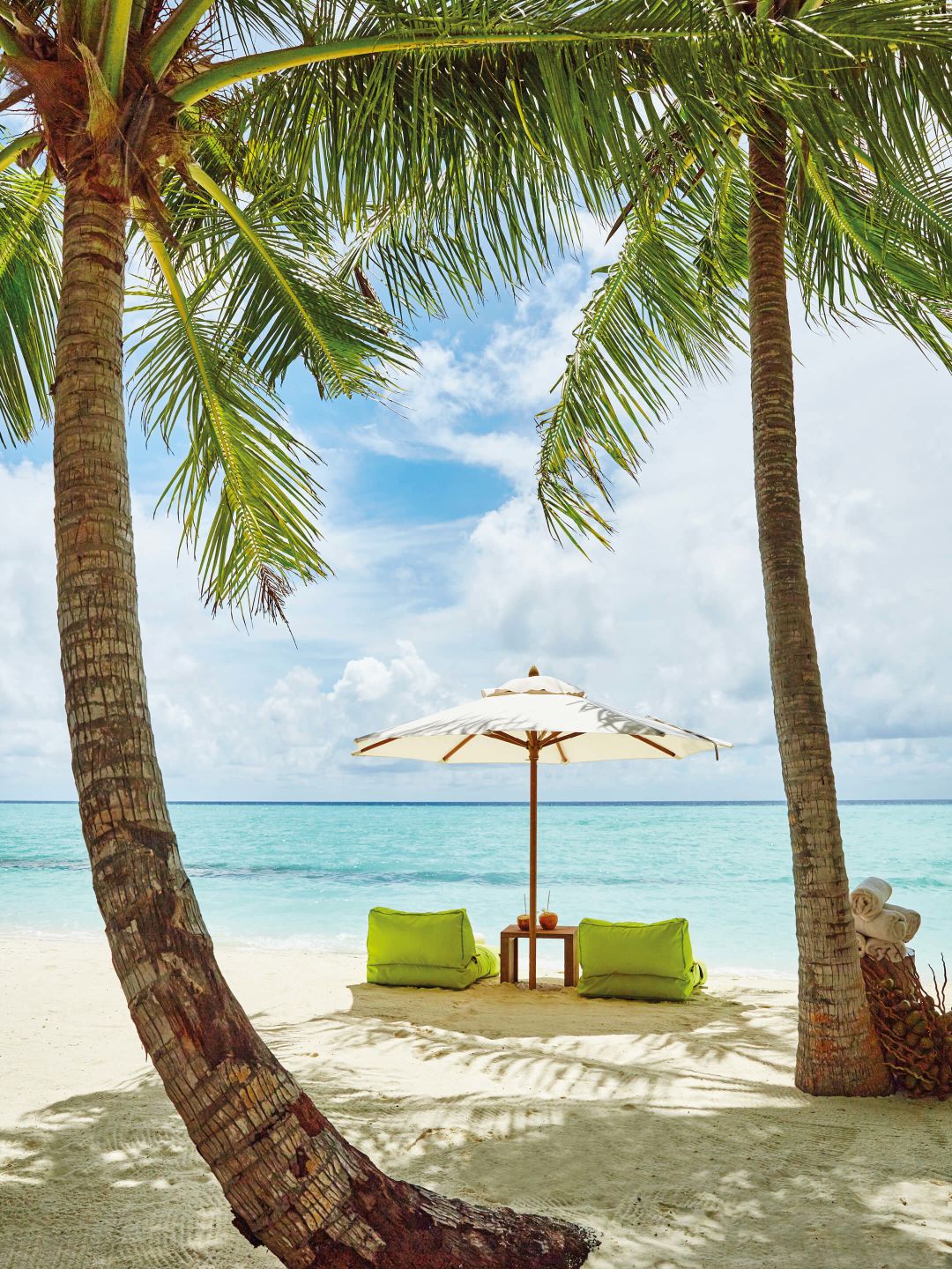 A Beach With Palm Trees And A Lounge Chair