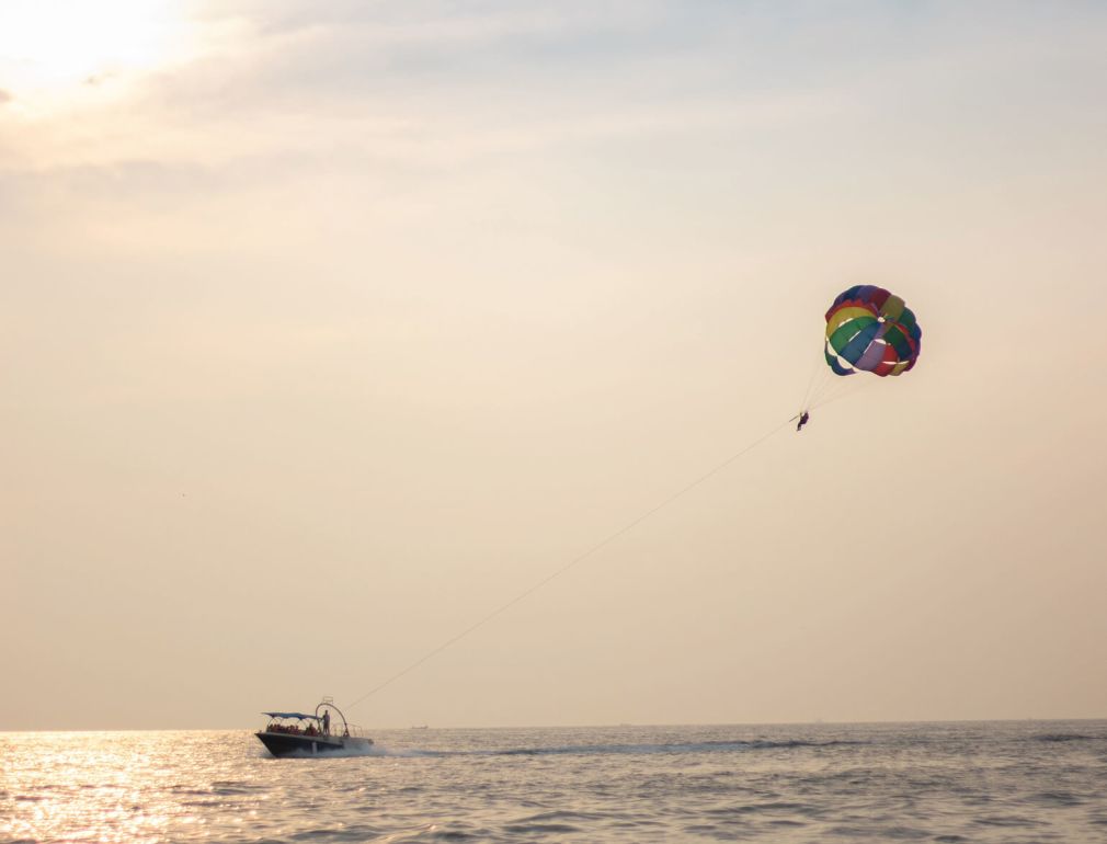 A Person Parasailing On The Water