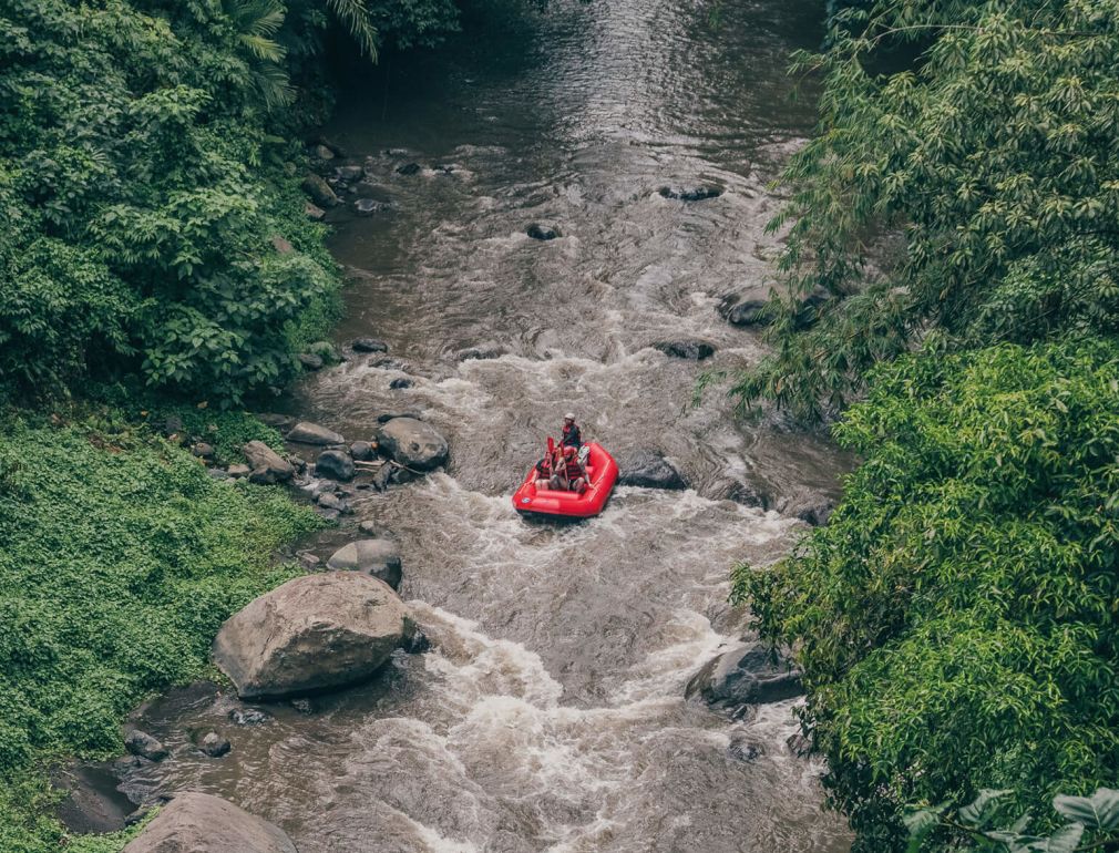 A Person In A Red Boat On A Dirt Road Surrounded By Trees