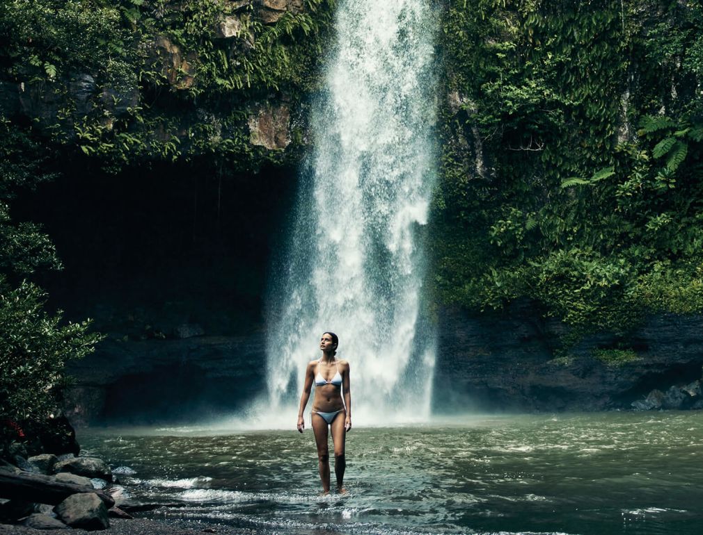 A Man Standing In Front Of A Waterfall