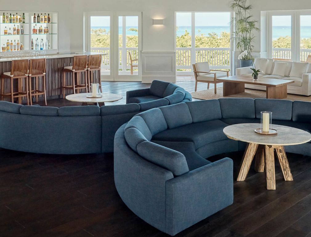 A Large Living Room With Blue Couches And A Wood Ceiling