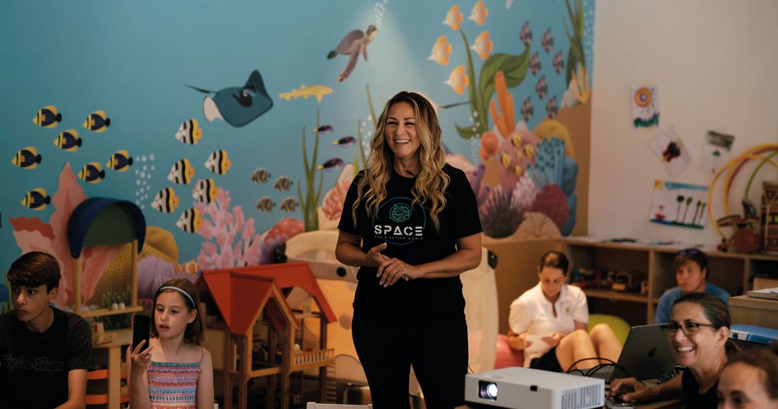 A Person Standing In Front Of A Classroom Of Children