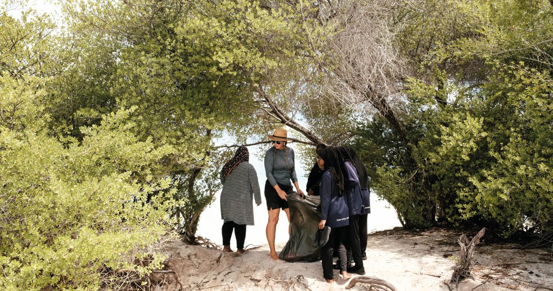 A Group Of People Walking On A Path In The Woods