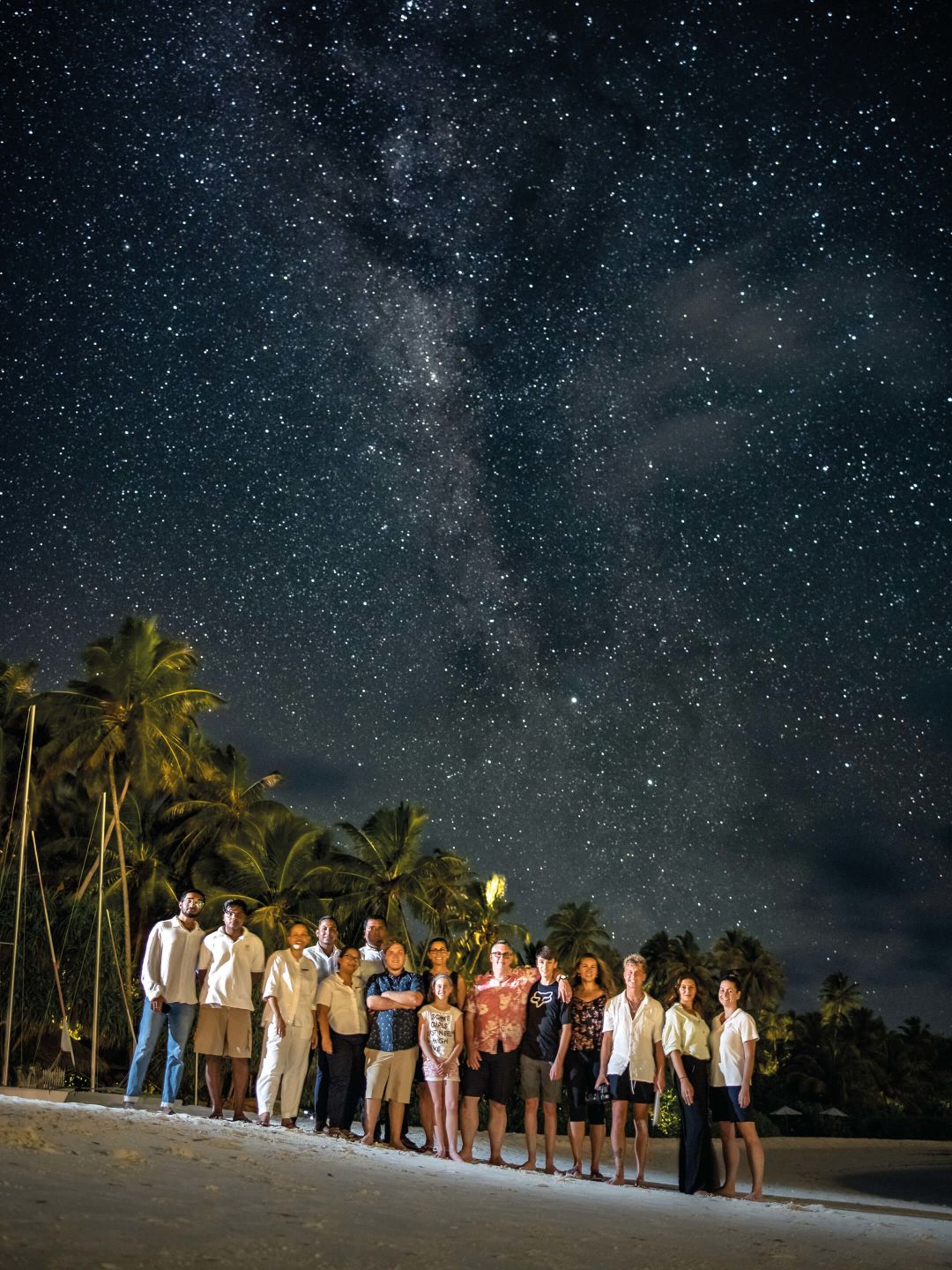 A Group Of People Posing For A Photo In Front Of A Starry Sky