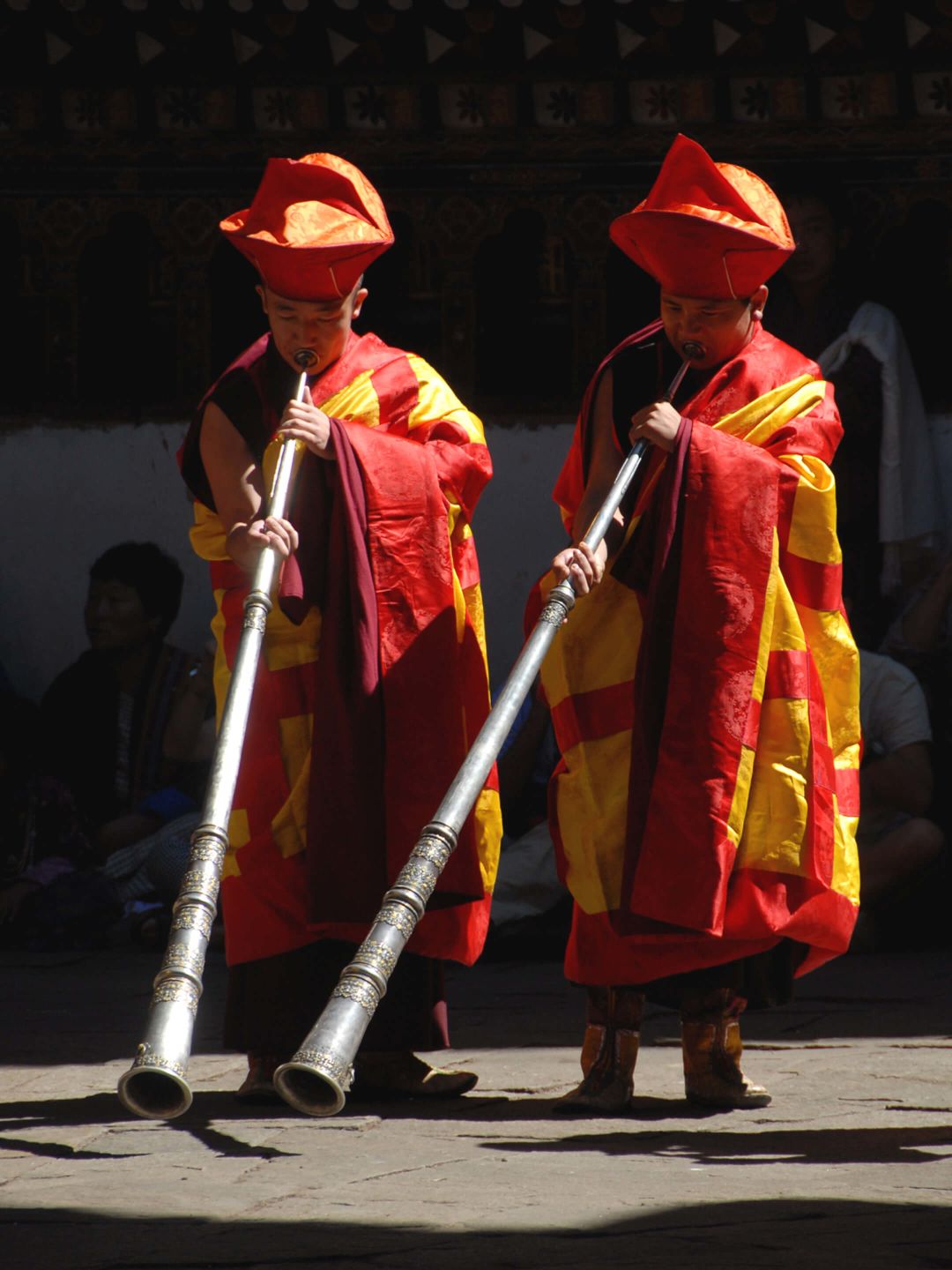 A Couple Of Men In Traditional Dress Holding Swords
