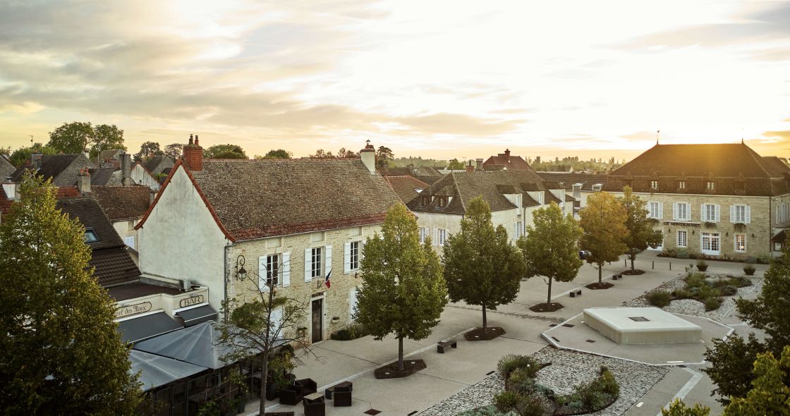 A Courtyard With Trees And Buildings In The Background