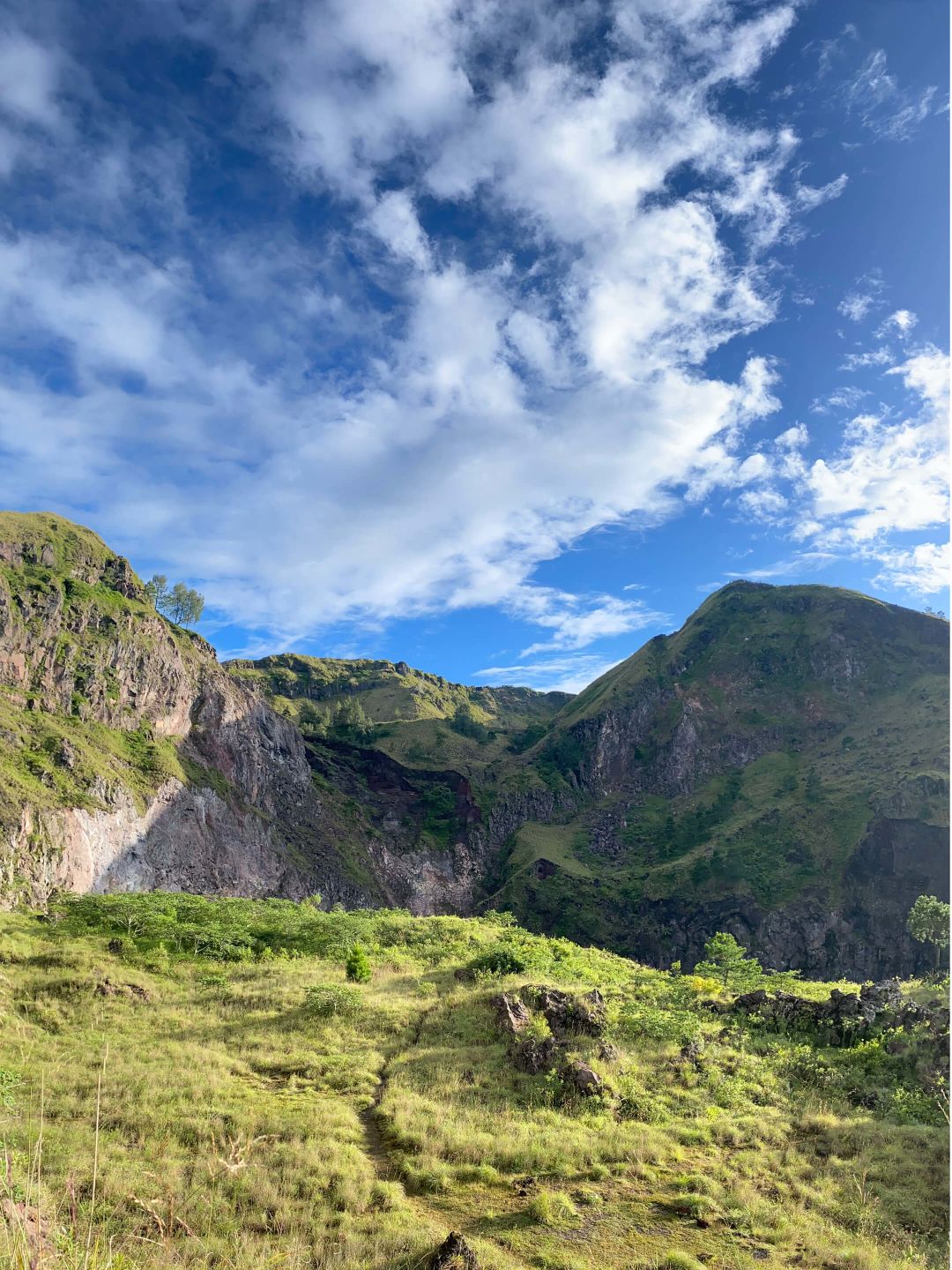 A Grassy Valley With Mountains In The Background