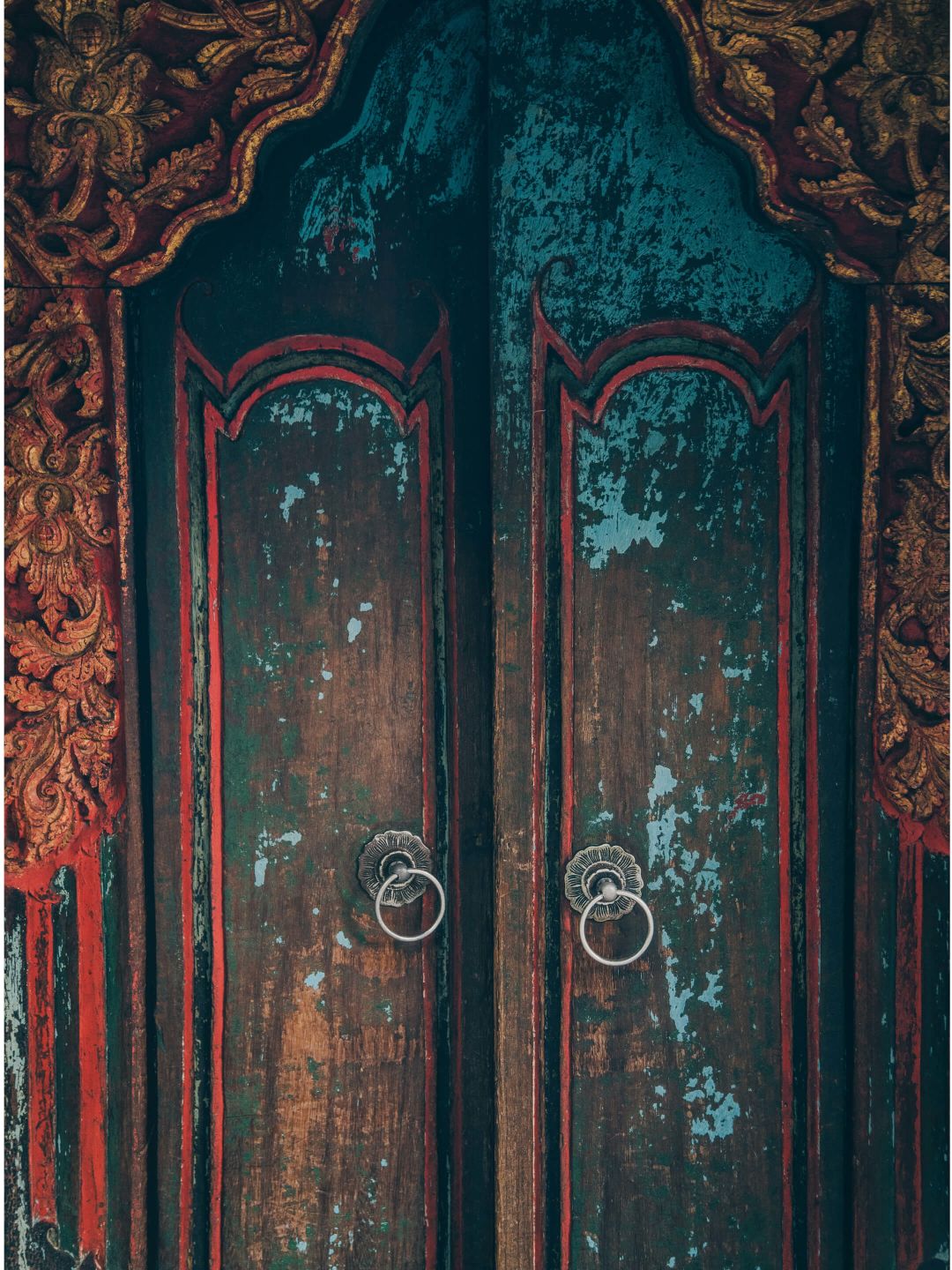 A Red Door With A Gold Design