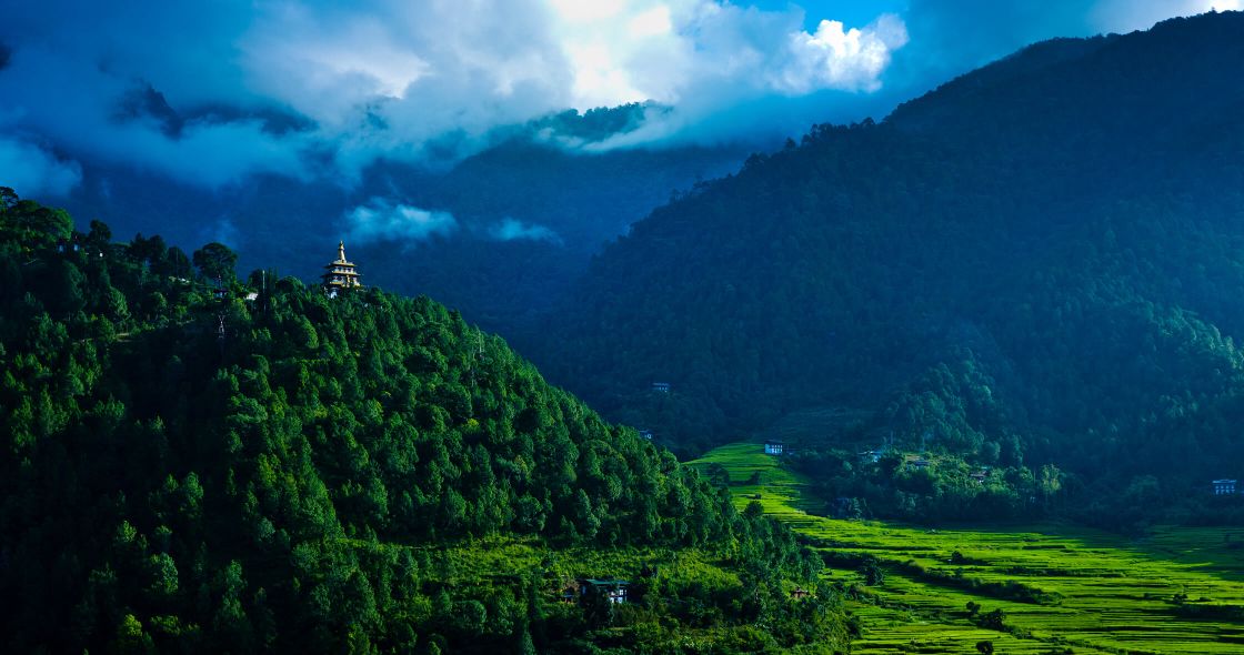 A Landscape With Trees And A Building In The Distance