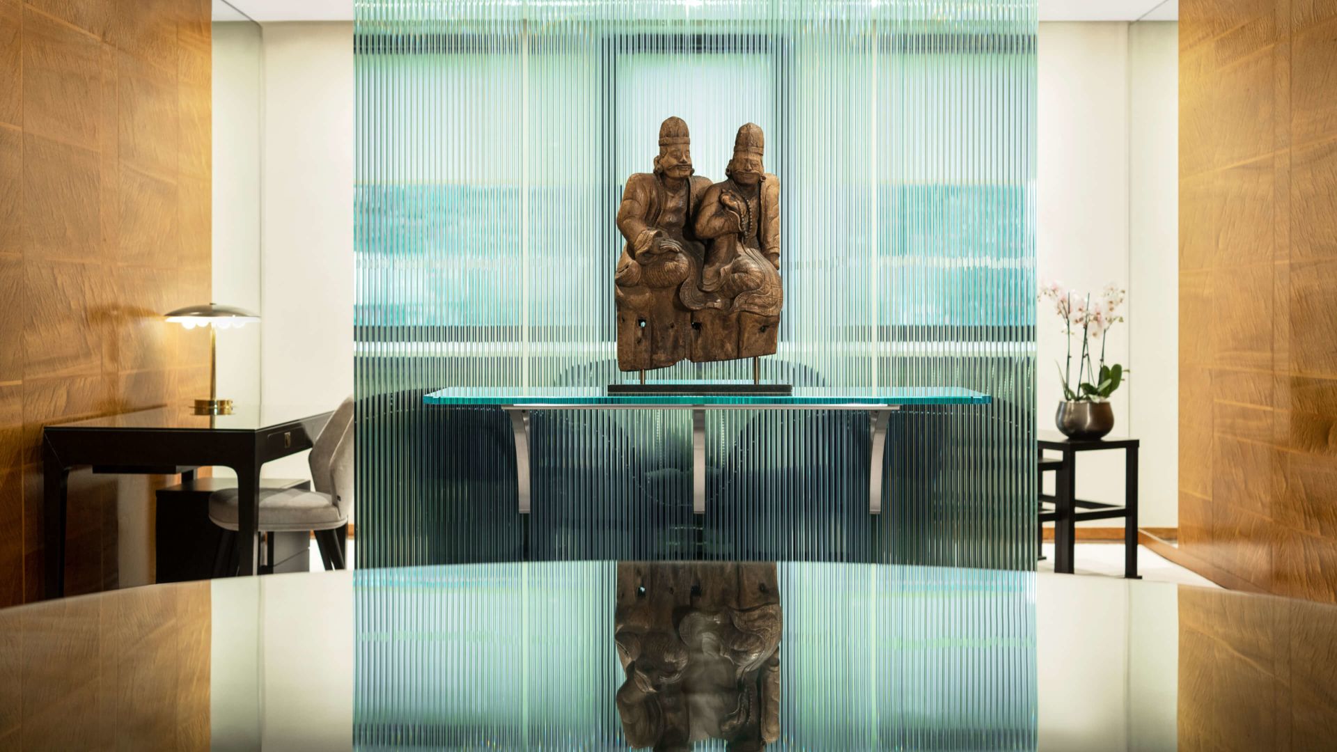 A Glass Table With A Statue On Top Of It