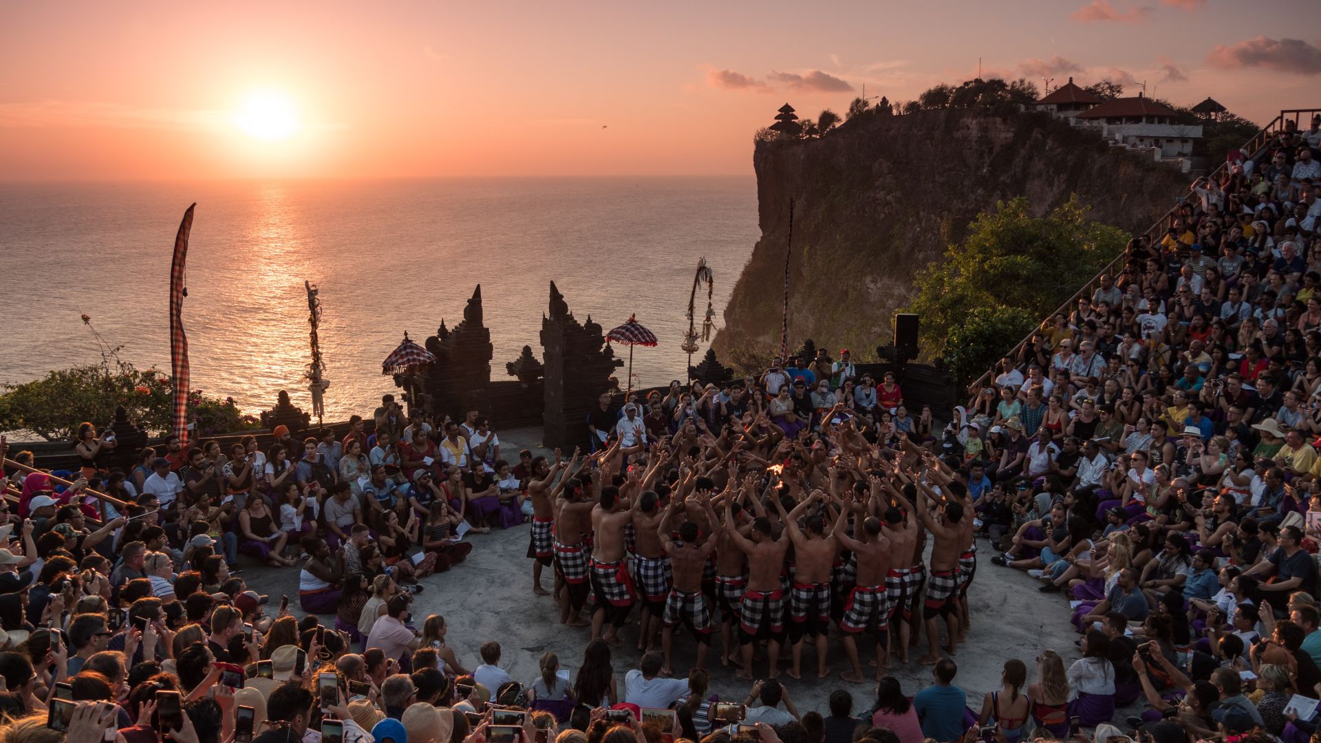A Large Group Of People In A Circle With A Bright Sun In The Background