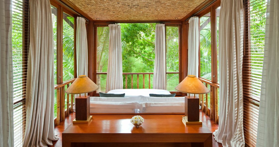 A Bedroom With A Bed And Lamps