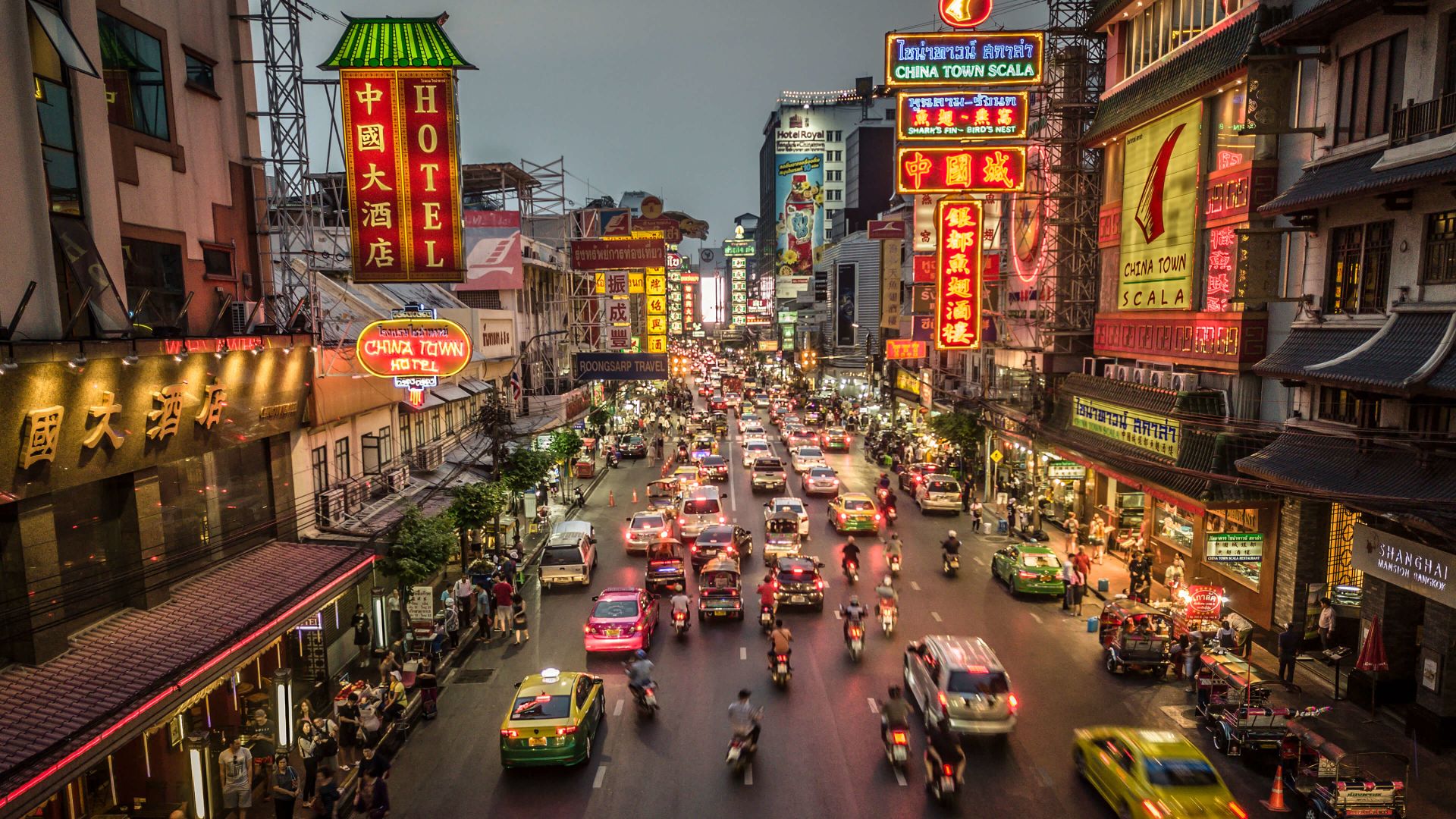 A Busy Street With Many Cars And Buildings