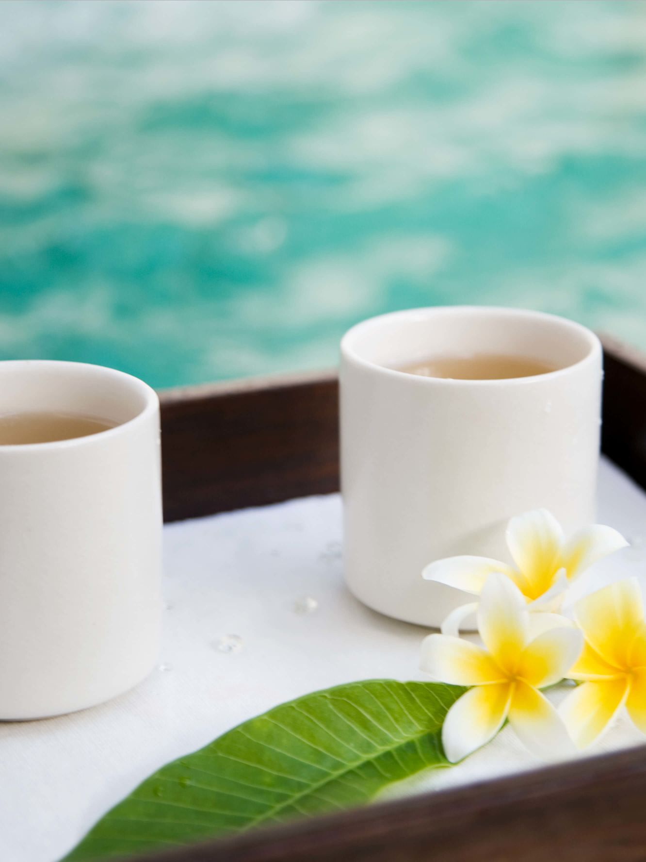 A Cup Of Tea And A Flower On A Table