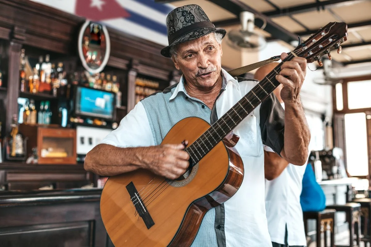 A Cuban man playing guitar in a bar