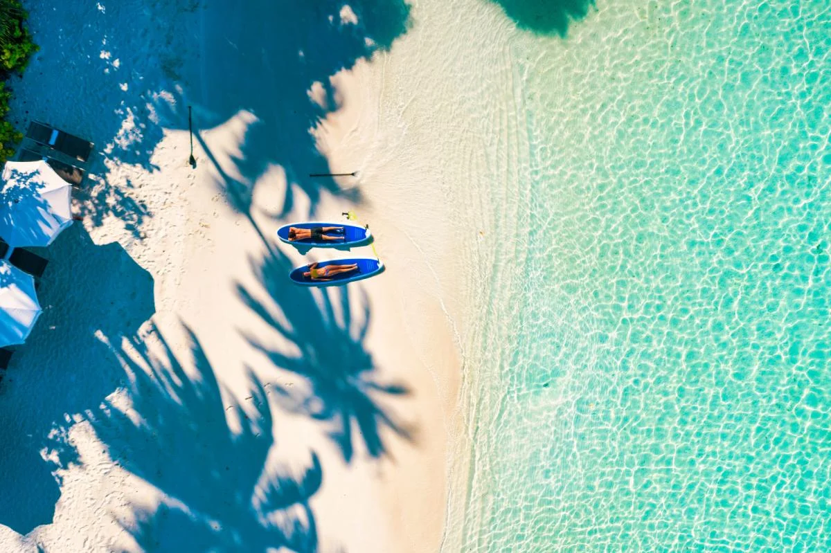 A couple in the Maldives taking a break from paddle boarding © iStock